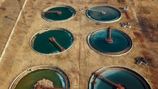 visione aerea di un impianto di trattamento delle acque reflue con grandi vasche circolari 