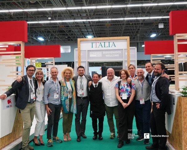 dodici esponenti italiani sorridono all'interno dello stand italiano di ecomondo messico