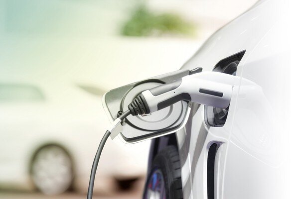 un veicolo elettrico mentre viene caricato tramite un caricatore elettrico inserito nell'apposito sportello di ricarica