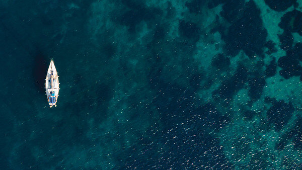 una barca che galleggia in un mare molto limpido