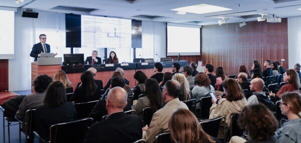  a seated audience listens to a conference on ethical and sustainable finance