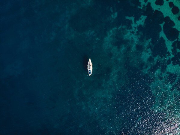 visione aerea di una piccola barca in mezzo al mare