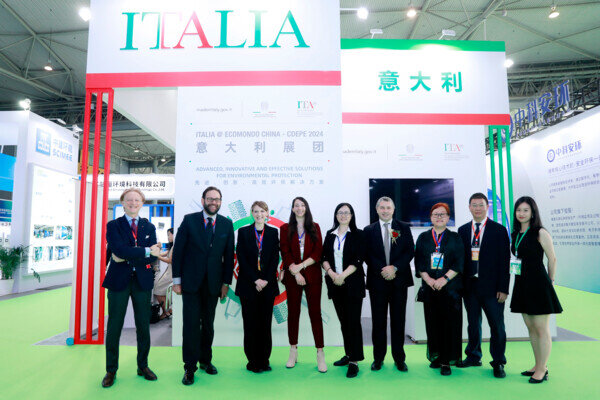 nove esponenti del settore sorridono di fronte allo stand italiano di ecomondo cina