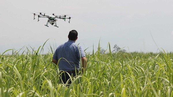 a man and a drone inside a farmed field