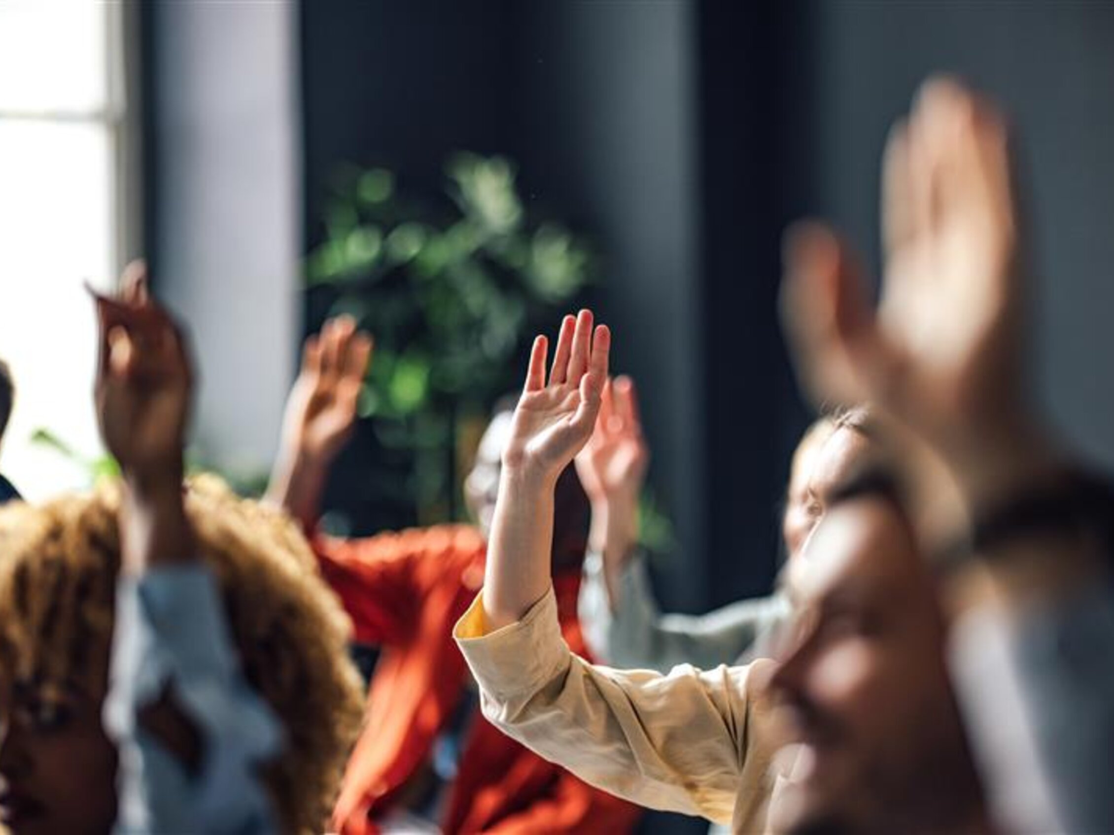 persone con le mani alzate durante una lezione
