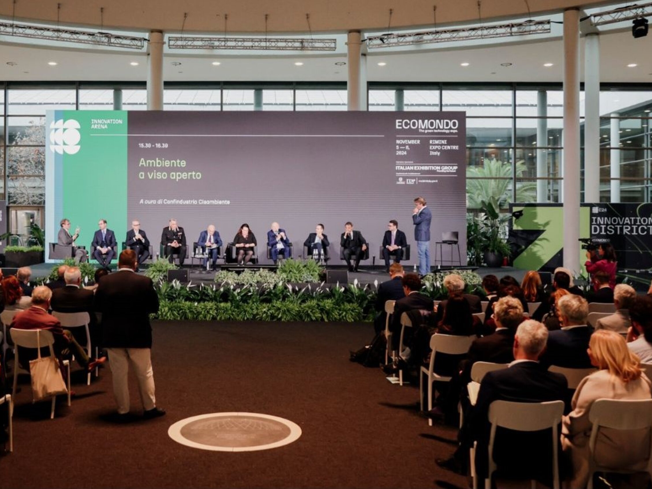 pubblico assiste ad un conferenza sull'ambiente con undici ospiti all'interno della cupola nella hall sud della fiera 
