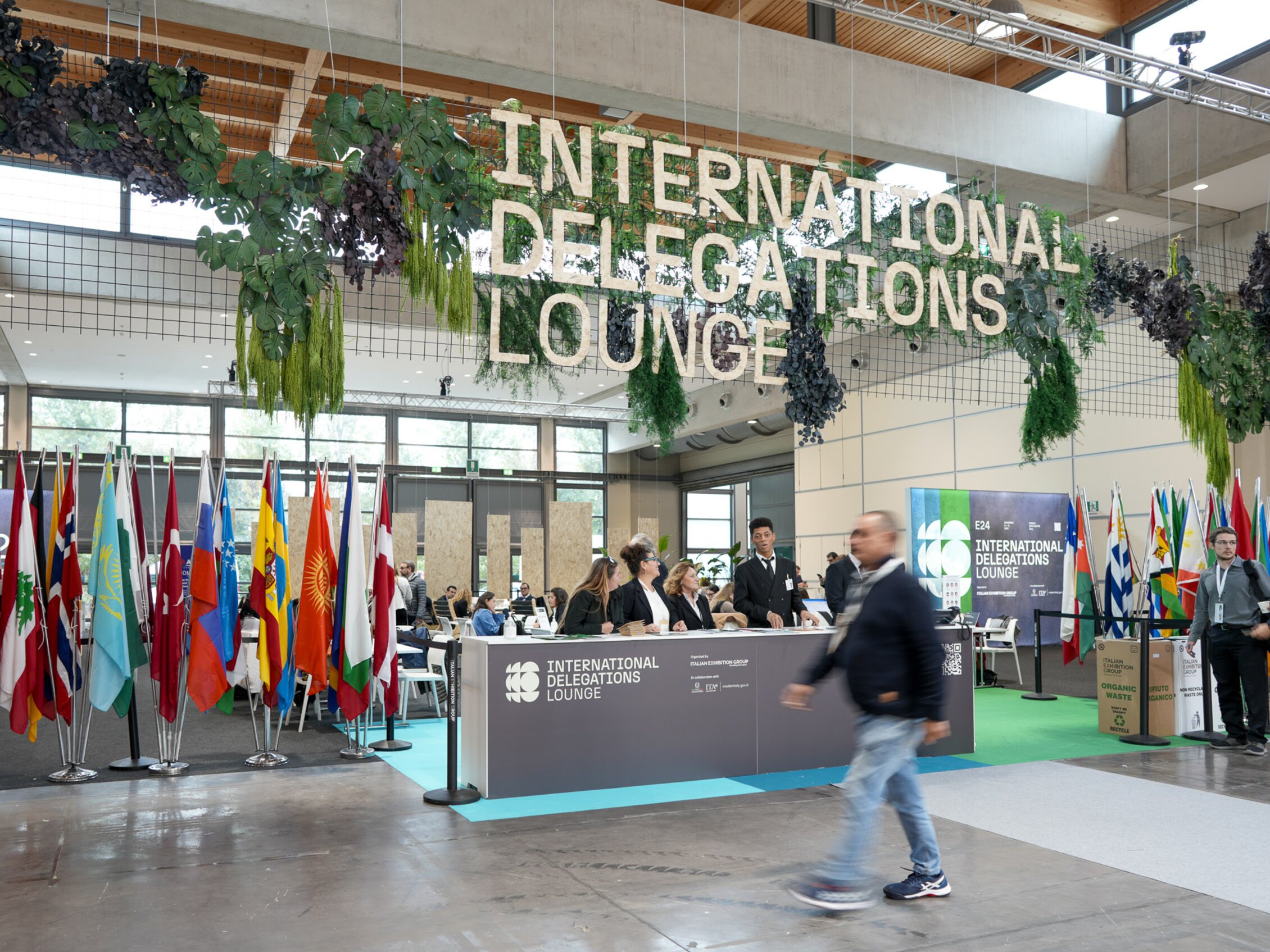 reception dell'International Delegations Lounge con bandiere internazionali e desk informativo, all’interno della fiera